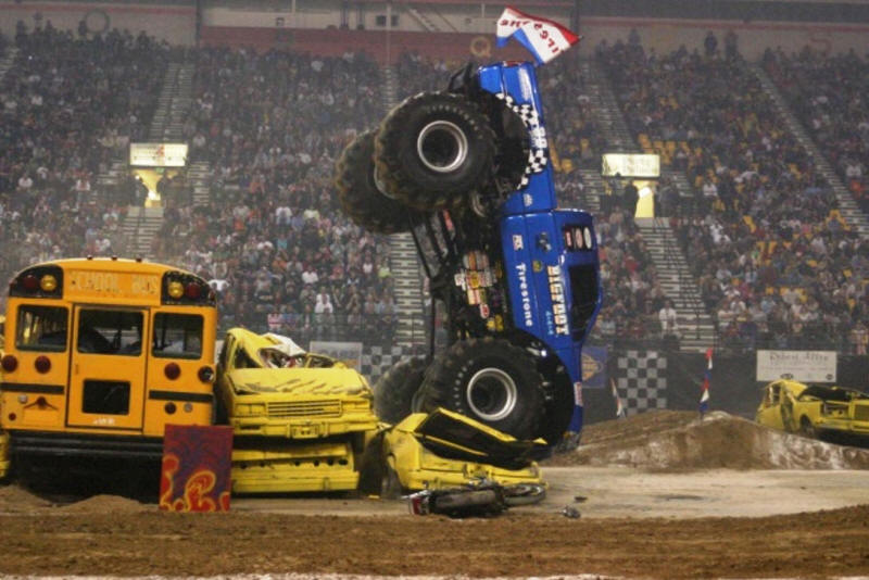 Bigfoot Monster Truck doing nose dive after jumping bus