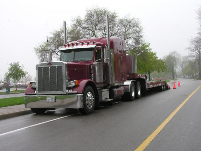 Peterbilt delivering heavy equipment on foggy morning Oakville, Ontario