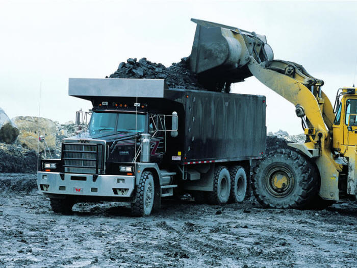 Western Star dump truck getting loaded by front-end loader at the quarry