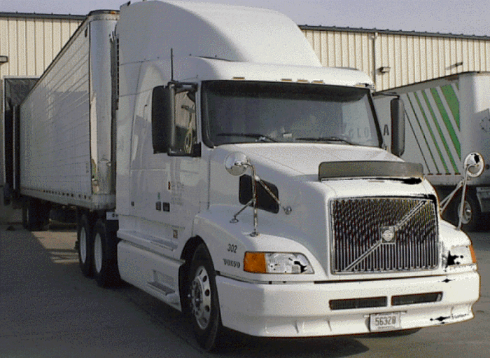 White Volvo "eighteen wheeler" Highway tractor with white dry van trailer at loading dock
