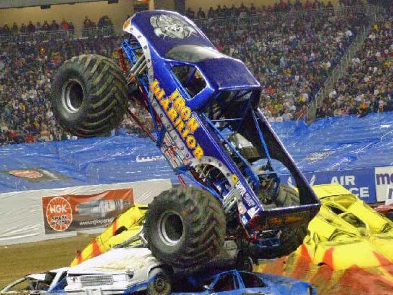 Iron Warrior Monster Truck walking right over and crushing a pile of cars