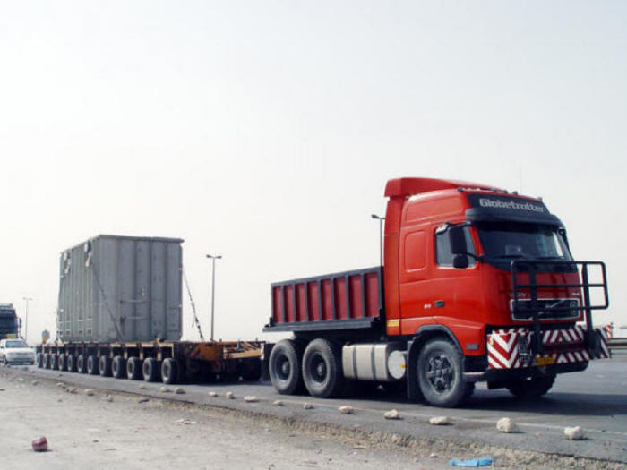 Red Volvo Globetrotter truck hauling heavy overweight load on trailer